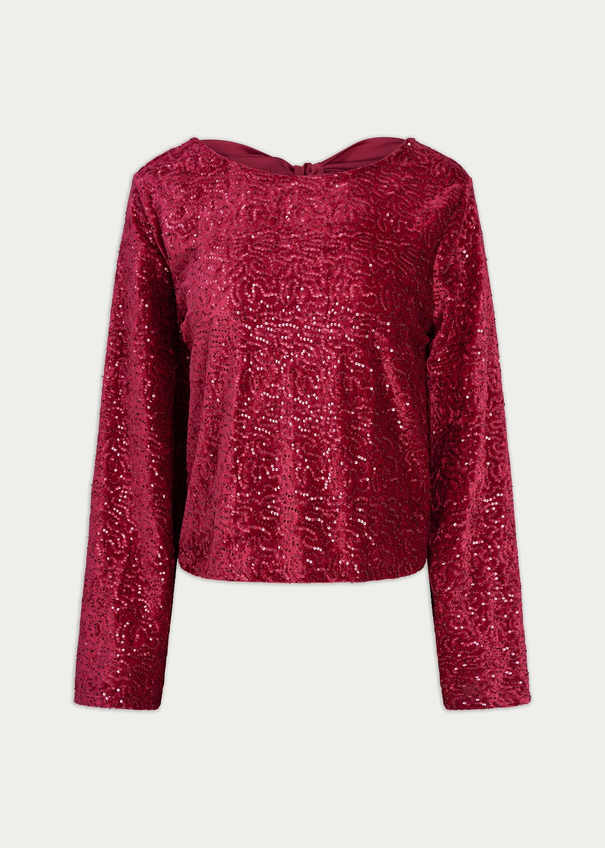 A long-sleeve cropped top covered in shimmering magenta sequins, featuring a wide boat neckline, shown against a light gray background.